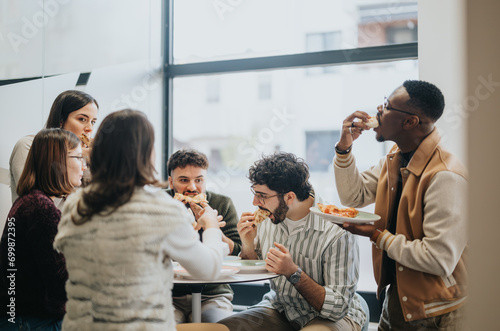 Confident coworkers enjoying a relaxing lunch break together, discussing and refueling their energy with delicious pizza. Successful teamwork and profit growth.