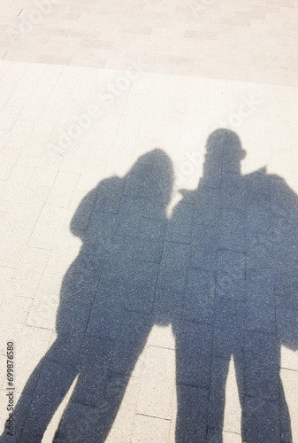 The shadow of a man and a woman on the asphalt
