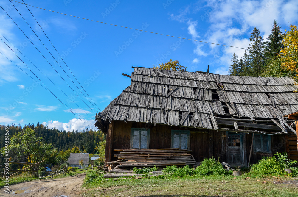 Rustic landscape with old wooden house abandoned in the village in the mountains. Carpathians, Ukraine