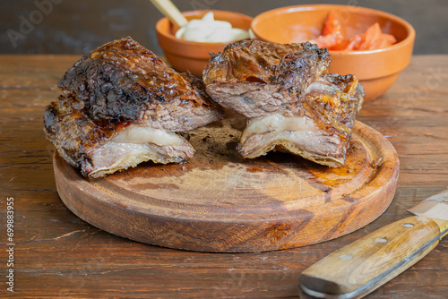 Piece of meat cooked on embers on a wooden plate. Traditional Argentinian food called 