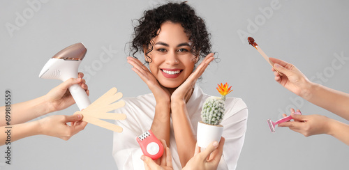 Fotografía Happy woman and hands suggesting different methods of epilation on grey backgrou