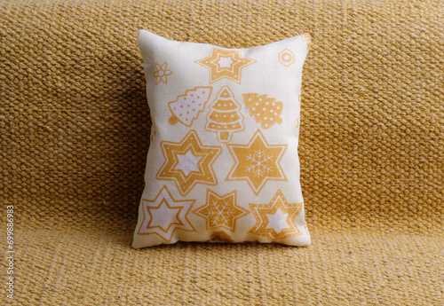Yellow holiday pillow with stars on the sofa