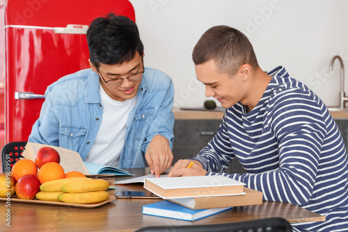 Male students studying in dorm kitchen