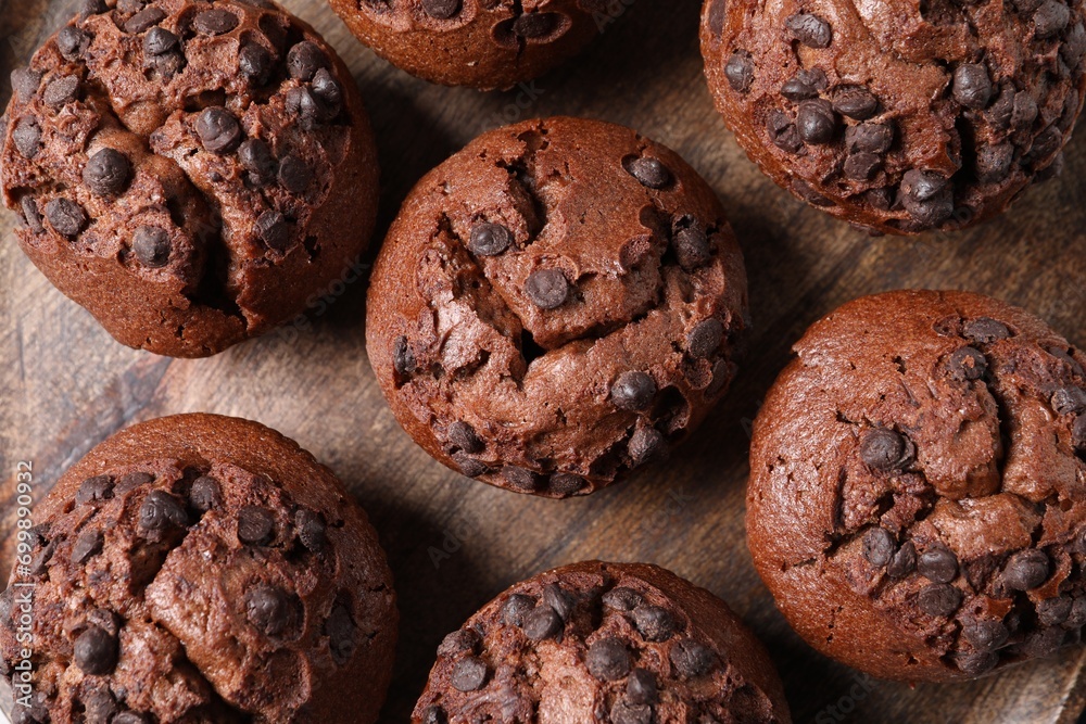 Tasty chocolate muffins on wooden board, flat lay Tasty chocolate muffins on wooden board, flat lay