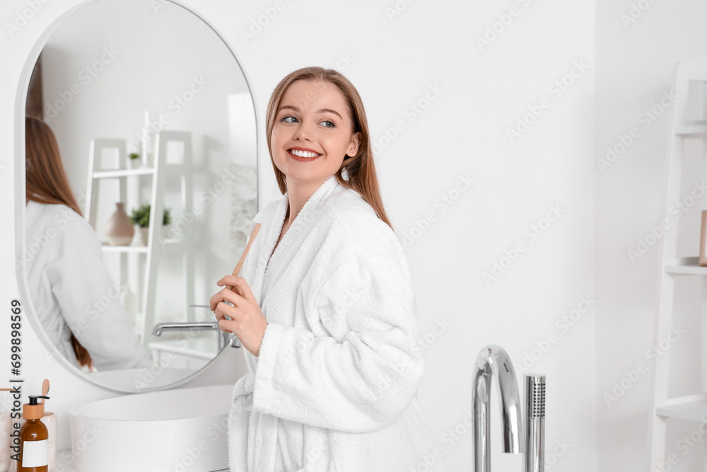 Young woman with toothbrush after shower in bathroom - obrazy, fototapety, plakaty 