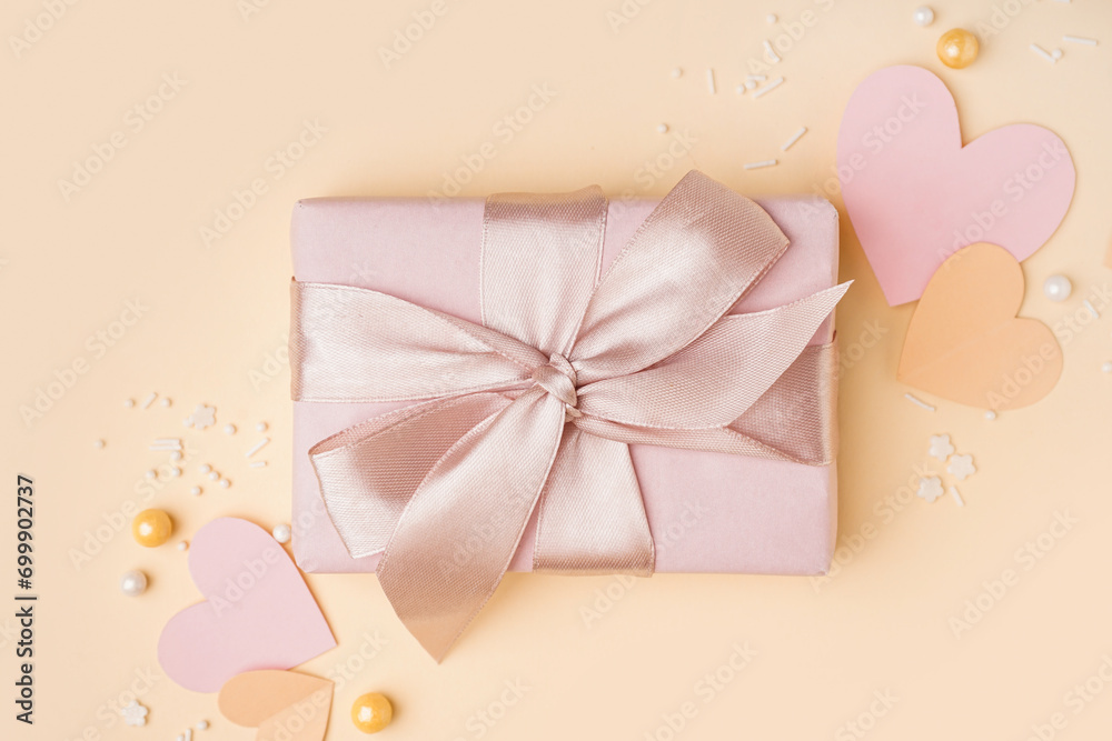 Gift box with paper hearts and decor on yellow background. Valentine's Day celebration