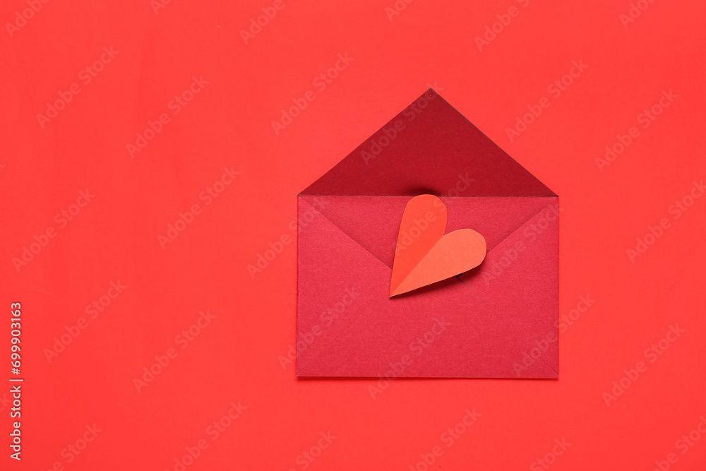Composition with envelope and paper heart on red background. Valentine's Day celebration Composition with envelope and paper heart on red background. Valentine's Day celebration