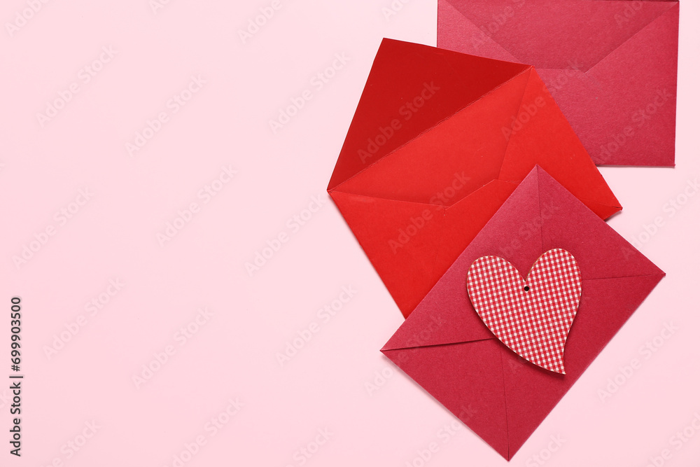 Obraz premium Composition with envelopes and paper heart on pink background. Valentine's Day celebration