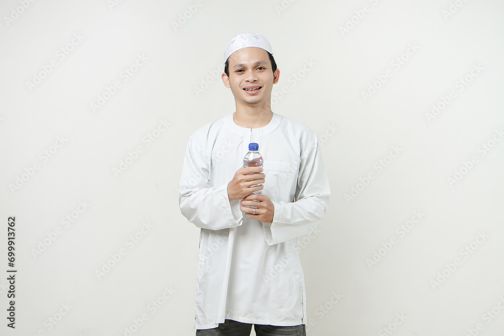 asian muslim man holding a water bottle with smile face on isolated background