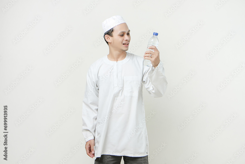 asian muslim man holding a water bottle with smile face on isolated background