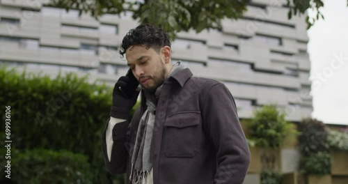 Wallpaper Mural Caucasian male in winter clothing wearing gloves and scarf talk outdoors with new smartphone in modern residential area of smart city Torontodigital.ca