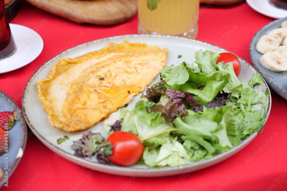 Plain Egg Omelette served with fresh salad on table 