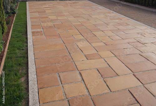 Laying gray concrete paving slabs in house courtyard driveway patio. Professional workers bricklayers are installing new tiles or slabs for driveway, sidewalk or patio on leveled sand foundation base.