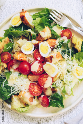 Classic caesar salad with grilled chicken, lettuce, croutons and parmesan cheese