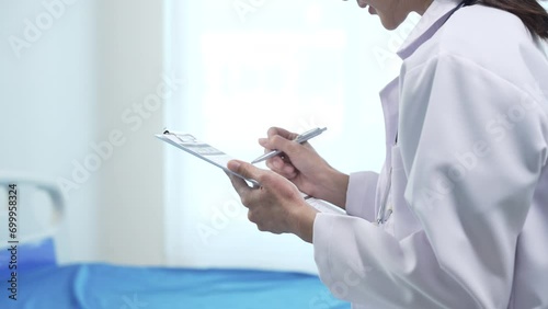 Asian people professional healthcare worker doctor, white coat, looking attentively at tablet in her hands. clinic or hospital with a bright and clean background. photo