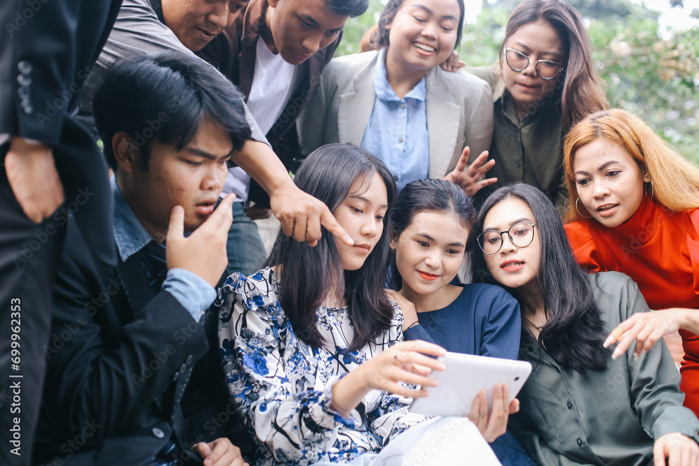 Group of businesspeople using a digital tablet together outside the office Group of businesspeople using a digital tablet together outside the office