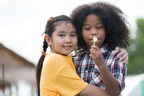 Two children girl playing and hugging together outdoors with happy and smile