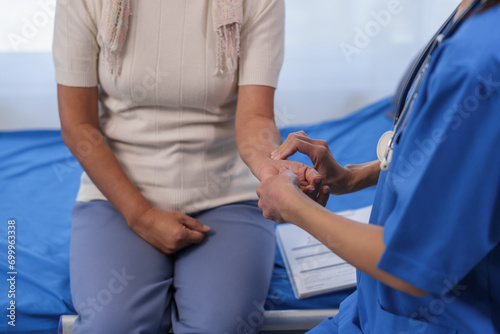 Health check concept, Elderly Asian woman with grey hair, sitting and talking to young Asian nurse by appointment, sitting on medical bed.
