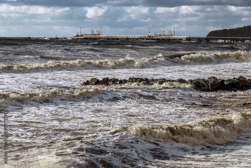 Photography Large waves crash against the shore under an impressive cloudy sky