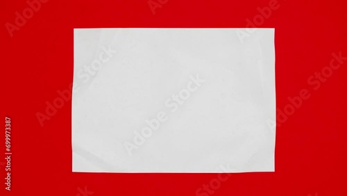 Blank sheet of white paper appears on red background from a paper ball, wrinkles again and disappears. Stop motion animation. 