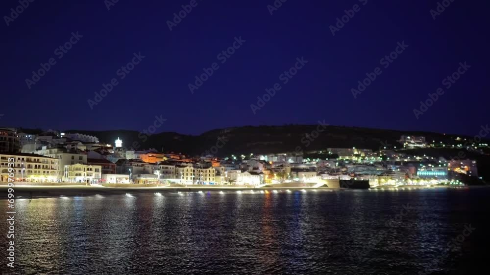 Portugal, Sesimbra at night from the sea as the city lights reflected on the Atlantic Ocean. Portugal, Sesimbra at night from the sea as the city lights reflected on the Atlantic Ocean.