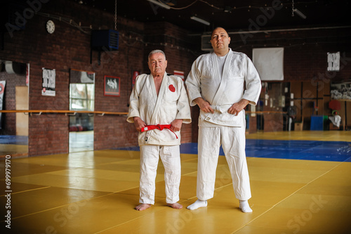Two respected and experienced judo sensei master instructor in traditional gi kimono. A skilled martial artist demonstrates his expertiset