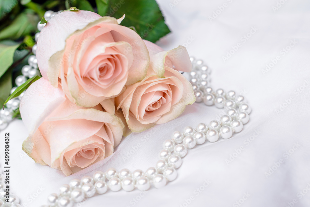 The branch of pink rose on white fabric background
