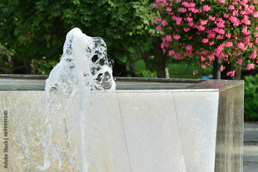 The urban white water fountain sprays up a geyser of water in the summer