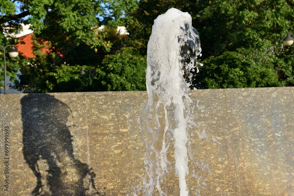 Spa splashing fountain on the stone square for guests