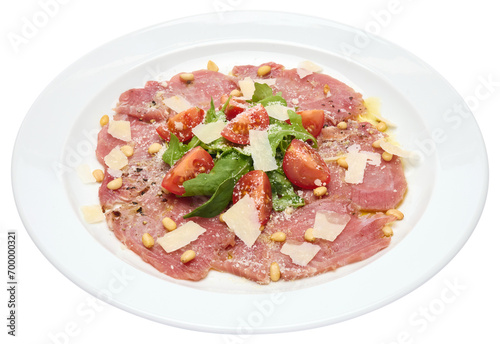 cooking tuna carpaccio - cherry tomato pieces on a plate with raw tuna fillet slices