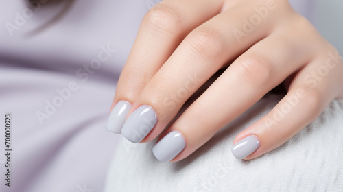 Glamour woman hand with gray nail polish on her fingernails. Gray color nail manicure with gel polish at luxury beauty salon. Nail art and design. Female hand model. French manicure.