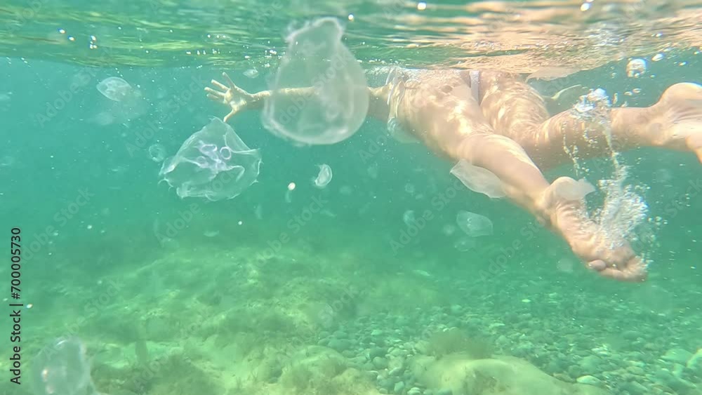 Young happy Woman in white bikini snorkels in the sea with a pink mask. Positive smiling woman relaxing and enjoying water activities with family summer travel holidays vacation on sea. Young happy Woman in white bikini snorkels in the sea with a pink mask. Positive smiling woman relaxing and enjoying water activities with family summer travel holidays vacation on sea.