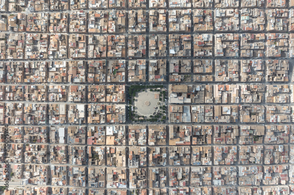 Fototapeta premium Symmetrically distributed city streets. Sunny day. View from the plane. Aerial view of Grammichele, a town near Catania, Sicily, Italy. 