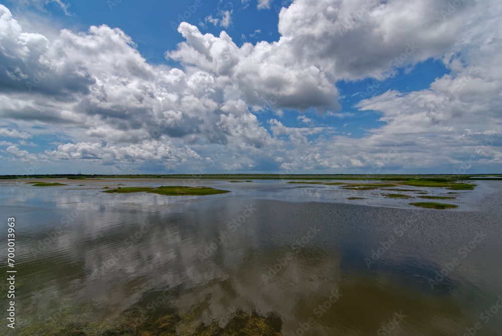 Reflections of Clouds in the still waters of a large lake in the San Bernard National Wildlife Refuge on the Gulf Coast of Texas.