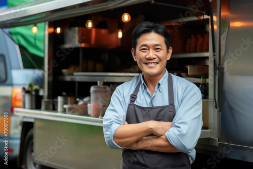 Portrait happy middle aged asian male smiling small business owner posing near his food truck photo