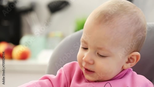 A mother's hand wipes snot from the nose of a little boy aged one year old who is sneezing and has a cold. Infection and viruses, close-up