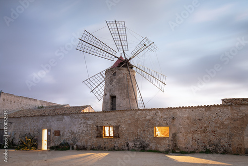 Sunset at Windmills in the salt evoporation pond in Marsala, Sicily island, Italy Trapani salt flats and old windmill in Sicily. View in beautifull sunny day.