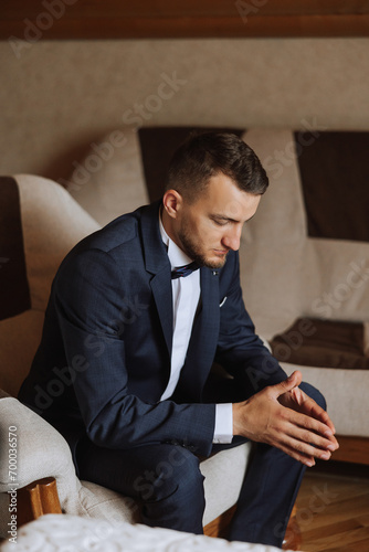Stylish portrait of the groom preparing for the wedding ceremony in the morning. Groom's morning. Preparation for the groom's morning. Husband's experiences before the wedding.
