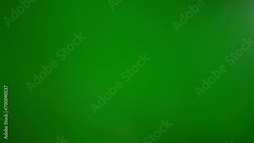 A man shows a what-you-want gesture with his hand on a green background photo