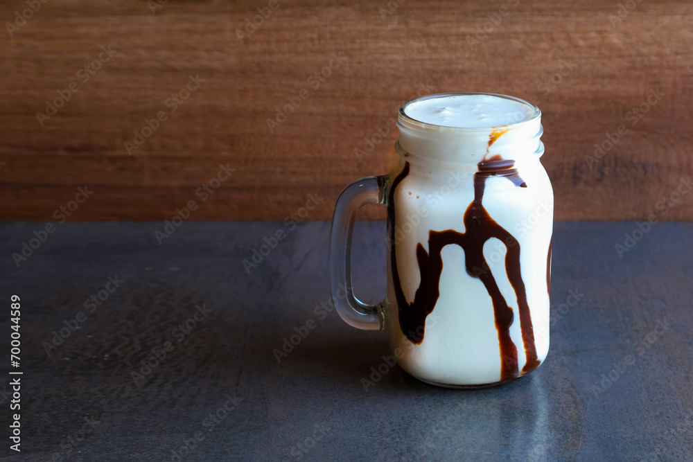 a glass of coffee and vanilla lata milkshake on a wooden background - obrazy, fototapety, plakaty 