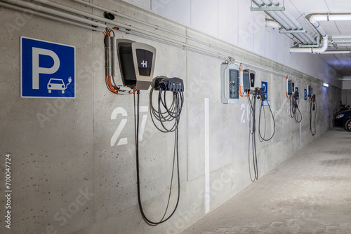 Charging Station for Electric Car EV in Underground Car Parking Garage in Multifamily Building. Electric Vehicle Charger Panel Station for Electro Cars. Home Power Charger.