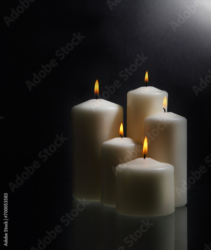 White candles over black background