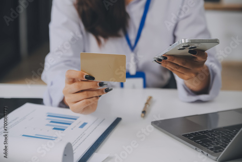.Women holding credit card and using smartphones at home.Online shopping, internet banking, store online, payment, spending money, e-commerce payment at the store, credit card, concept photo