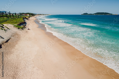 Summer beach and blue ocean with waves in Brazil. Aerial view of Morro das Pedras in Santa Catarina