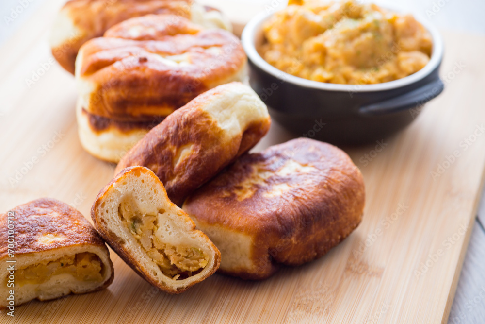 Fried Lenten pies filled with cooked peas inside, on a wooden table. Fried Lenten pies filled with cooked peas inside, on a wooden table.