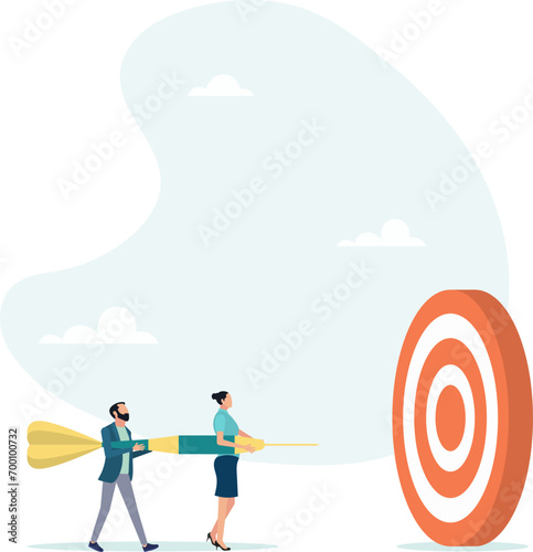 Team business goal, team cooperation to achieve the goal. Colleagues with the same task. A businessman and a businesswoman help hold a dart while aiming for the bull's-eye target.
