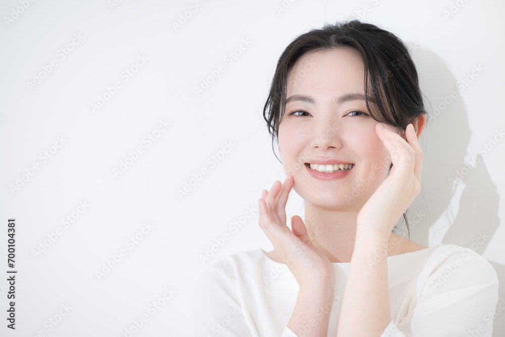 Busty woman smiling with hands on cheeks, close up of grouped hair female beauty on white background Busty woman smiling with hands on cheeks, close up of grouped hair female beauty on white background
