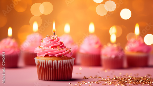 Composition with tasty pink birthday cupcake with candle on pink background