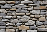 close-up view of rough stone wall. The wall is made of different stones, each with its own unique texture and shape.