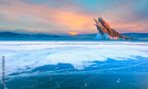 Baikal lake in winter with transparent cracked blue ice. Ogoy island, Baikal, Siberia, Russia. Beautiful winter landscape at sunrise. © muratart